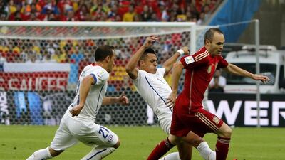 Andres Iniesta,right, of Spain in action with Alexis Sanchez centre, of Chile during their 2014 World Cup Group B match on Wednesday in Rio de Janeiro, Brazil. Abedin Taherkenareh / EPA