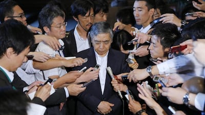 Bank of Japan (BOJ) governor Haruhiko Kuroda (C) speaks to the media after meeting with Japan's prime minister Shinzo Abe at Abe's official residence in Tokyo on September 11, 2014. Kuroda on Thursday said he told Abe that the central bank will not hesitate to ease policy further if its 2 per cent inflation goal becomes difficult to achieve. But he also told Abe that a positive economic cycle in Japan is firmly in place, suggesting there is no immediate need to act. Toru Hanai / Reuters