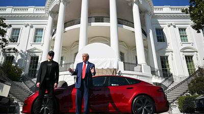 US President Donald Trump and Tesla chief executive Elon Musk stand next to a Tesla car as they address the press outside the White House in Washington. AFP