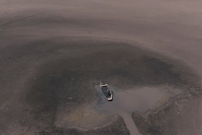 A worker collects mud at Serbia's Lake Rusanda, which dried up for the first time in recorded history during a prolonged heatwave 2024. Getty Images