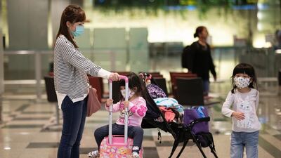 Travellers are seen wearing masks at Changi Airport in Singapore. The city closed its borders to passengers from China, including foreigners who have been in the country for 14 days. EPA