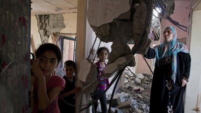Farida Aziz with her children as they visit their damaged apartment building in the UAE-funded $66m Sheikh Zayed City residential compound in Gaza. The family was at home on the night of July 14 when the apartment building received an Israeli air strike warning. They fled and when they returned, they saw that their home had been destroyed. Heidi Levine for The National