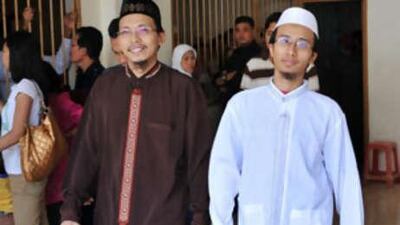 Agus Purwanto, left, and Parmin, two of three senior militants who allegedly aided top operatives from Jemaah Islamiyah JI, are escorted by plain clothes police before their trial at the Central Jakarta court on Oct 20 2008.