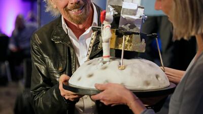 Richard Branson is presented with a space-themed cake during a luncheon attended by 100 Virgin Galactic ticket holders, to mark his 69th birthday. Photo: AP