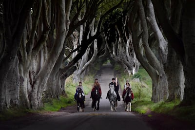 Four actors on horseback dressed in Game of Thrones costumes carry the Queen's Baton as they make their way along Bregagh Road in Antrim, Northern Ireland. Getty Images