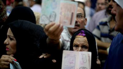 Palestinians show their passports to the camera as they wait at the Rafah border crossing in the southern Gaza Strip on Wednesday. Mohammed Abed / AFP