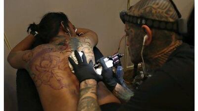 A tattoo artist inks a customer's back during the Nepal Tattoo Convention in Kathmandu last week. Some 57 tattoo artist from 10 countries participated.