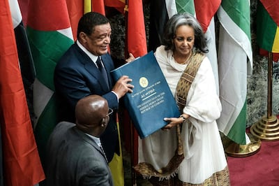 Ethiopia's first female President Sahle-Work Zewde, right, receives a book of the Constitution from former President Mulatu Teshomea at the Parliament in Addis Ababa. AFP