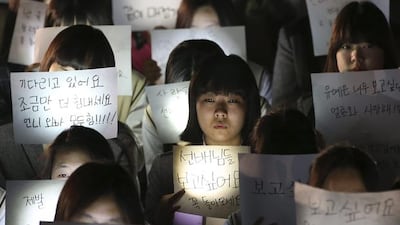 Students hold papers with candles for safe return of their friends aboard the sunken ferry Sewol at Danwon High School in Ansan, south of Seoul, South Korea. Yonhap / AP