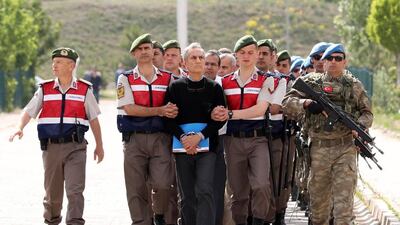 Turkish Gendarmerie escort defendants Akin Ozturk, third left, and others involved in last July’s attempted coup in Turkey as they leave the prison where they are being held, ahead of their trial in Ankara, on May 22, 2017. The trial opened on May 22, 2017 with more than 220 suspects, including over two dozen former Turkish generals, accused of being among the ringleaders of the attempted coup last year. Adem Altan/AFP