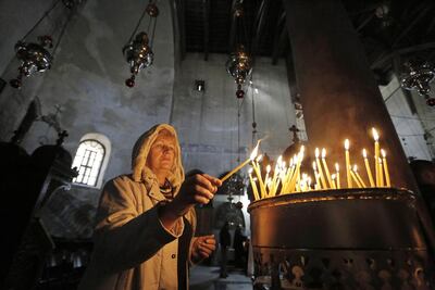 A tourist lights a candle at the Church of Nativity, revered as the site of Jesus’ birth, ahead of Christmas in the West Bank town of Bethlehem. Reuters