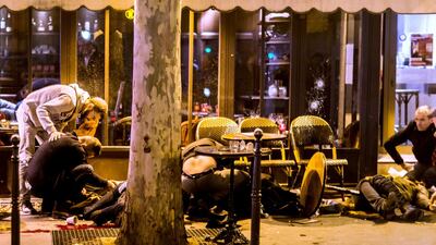 People lie on the pavement at the terrace of the cafe "A la Bonne Biere" in Paris on November 13, 2015, following a series of co-ordinated attacks in and around Paris that left more than 120 people dead. Anthony Dorfmann / AFP