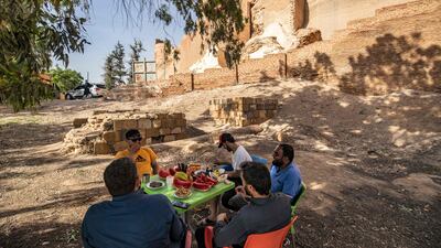 Men share a meal at the ruins.