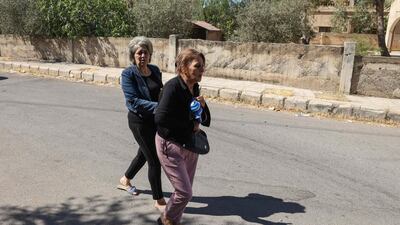 Women rush on a street as they flee their homes amid the clashes. AFP