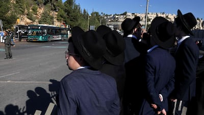 Ultra Orthodox Jewish youths watch Israeli security forces working at the scene of an explosion at a bus stop in Jerusalem. AFP