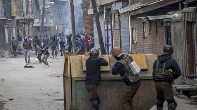 Indian security forces take cover on November 4, 2016, behind a rubbish bin set up as a roadblock by Kashmiri protesters on the outskirts of Srinagar, Indian-controlled Kashmir. The area has seen almost daily protests since the July 8 killing of a popular rebel commander by Indian forces. Dar Yasin / Associated Press