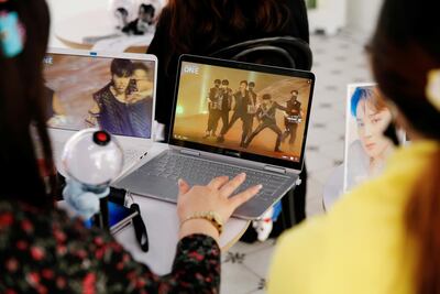Fans of K-pop boy band BTS watch a live streamed online concert in a cafe in Seoul, South Korea, on October 10, 2020. Reuters