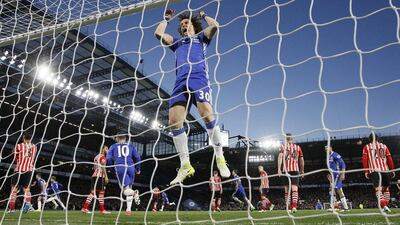 David Luiz celebrates by swinging on the crossbar after Gary Cahill’s goal. Alastair Grant / AP Photo