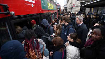 People queue for buses outside Victoria Station in London. EPA