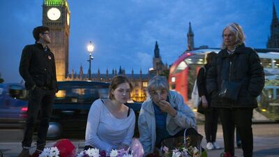 Members of the public look at floral tributes left in memory of British MP Jo Cox in Parliament Square, London. The Labour MP was murdered in Birstall, West Yorkshire, while meeting members of the public in her constituency. Will Oliver / EPA