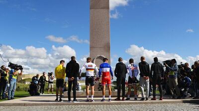 Stage winner Mark Cavendish of Great Britain and Team Dimension Data (R) and fellow riders observe a minutes silence at a war memorial at Utah Beach after Stage 1 of Le Tour de France 2016 on July 2, 2016 in Sainte-Marie-du-Mont, France. Bryn Lennon / Getty Images