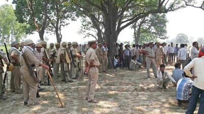 Villagers and policemen gather around a tree in Katra village in Uttar Pradesh where the bodies of two teenage cousins were found hanging after being gang raped. EPA / May 28, 2014