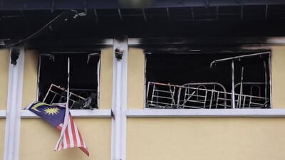 A Malaysian national flag and a burning bed are visible in the window of school room after a fire broke out at a religious school in Kuala Lumpur, Malaysia. Fazry Ismail / EPA