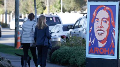 Pedestrians walk past a billboard featuring Prime Minister Jacinda Ardern with the word Aroha, meaning love, in Christchurch, New Zealand. AP Photo
