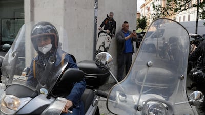 A man takes a picture near a mural depicting coach Jose Mourinho riding a Vespa scooter. AP
