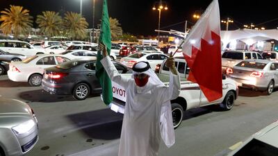 A Bahraini man holding Saudi and Bahraini national flags welcomes Saudis as they enter Bahrain on the King Fahd Causeway after Saudi Arabia lifted a 14-month-long travel ban on its citizens on May 17, 2021. Reuters