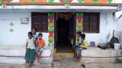 Widow P.Lalitha (2nd L), who lost her husband in a road accident, sits along with her children at their home. Noah Seelam / AFP