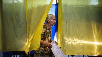 A woman holds her ballot as she leaves a polling station in the eastern Ukrainian town of Dobropillya on May 25, 2014. Dimitar Dilkoff/AFP Photo