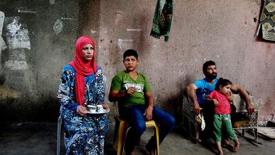 Tamara, 14, sits next to her husband Ahmed Soboh, 15, as her father Emad, 38, rests at right, at their home in Beit Lahiya, northern Gaza Strip. Adel Hana / AP Photo