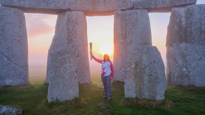 Sally Orange carries the baton at Stonehenge. Getty Images