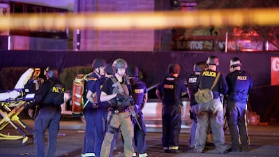 Police officers and medical personnel stand at the scene of a shooting near the Mandalay Bay resort and casino on the Las Vegas Strip. John Locher / AP Photo