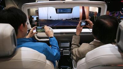 Show attendees experience autonomous driving mode in the Hyundai MOBIS ‘i-Cockpit Car,’ an experiential simulator of future car driving. Alex Wong / Getty Images / AFP