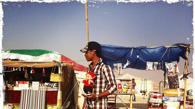 Day trip with friends to the Western Region and the Mazayin Dhafra Camel Festival, 220 kms west of Abu Dhabi on December 20, 2013. A man selling a stuffed toy on the side of the road. Picture taken with the Hipstamatic app for the iPhone. Liz Claus / The National