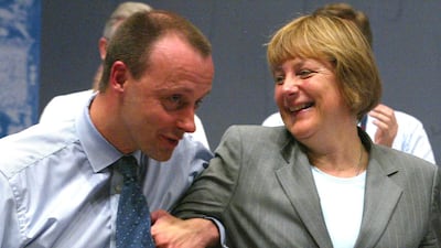 Friedrich Merz, parliamentary floor leader of the conservative German Christian Democratic Union party jokes with Angela Merkel after addressing the CDU party convention in Frankfurt, June 18, 2002. Reuters