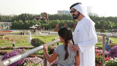 The Ruler of Dubai looks out onto the gardens with his daughter Sheikha Al Jalila.