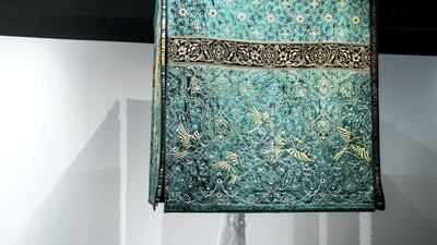 Visitors to Abu Dhabi Art interact with the work of Pakistani artist, Aisha Khalid. 'The Garden of Love is Green Without Limit' includes a hanging fabric structure that resembles the Kaaba and its cloth cover, and the tapestry’s colour is borrowed from the dome of the Prophet’s Mosque in Medina. Reem Mohammed / The National