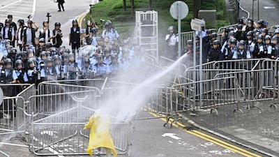 Police use a water canon on a lone protester. AFP