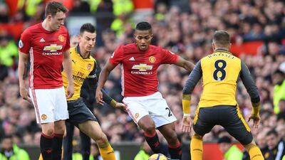 Deflated Arsenal, in yellow, and an understrength Manchester United side will likely play out a draw at Emirates Stadium this week. Paul Ellis / AFP