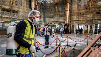 An Egyptian worker sprays disinfectant at Cairo's Ramses railway station. AFP