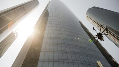 A drone being used to inspect the exterior of Etihad Towers in Abu Dhabi in August last year. Four drone no-fly zones and nine areas requiring registration have been established across Dubai. Christopher Pike / The National