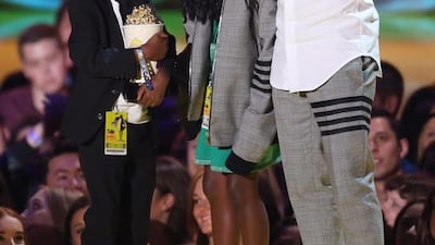 Kevin Hart, right, appears on stage with his kids Hendrix Hart, left, and Heaven Hart as he accepts the comedic genius award at the MTV Movie Awards in Los Angeles. Matt Sayles / Invision / AP
