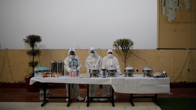 Hospital staff wearing personal protective equipment wait for coronavirus patients during an evening buffet on the outskirts of New Delhi, on September 15, 2020. Reuters
