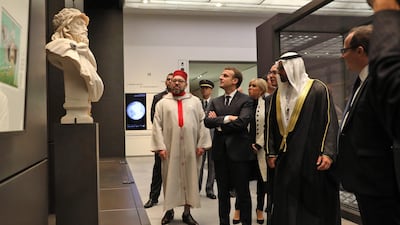 King Mohammed VI of Morocco, French President Emmanuel Macron, his wife Brigitte and Director General of Abu Dhabi's Tourism and Culture Authority Saif Saeed Ghobash look at a piece of art. Ludovic Marin / AFP Photo