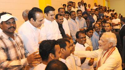 Mr Modi greets a group of Indian workers living in Abu Dhabi. Wam