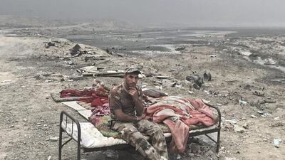 Alaa Hashid, from Shura, Iraq, an Iraqi army soldier, poses for a portrait at a checkpoint in Qayara.