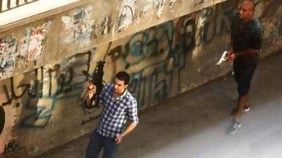 Two civilians holding guns walk on a street in the Zamalek neighborhood of Cairo on Friday. Manoocher Deghati / AP Photo